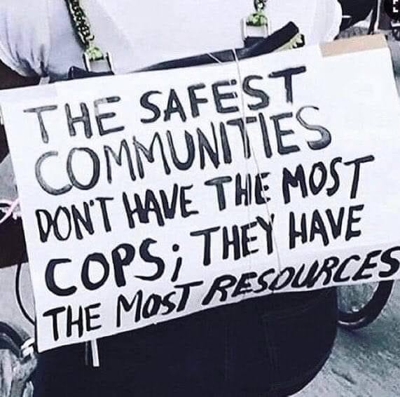 The meme is a humorous image that pokes fun at the idea that the police are the most trusted and important part of a community. The text on the sign reads: "The safest communities don't have the most cops, they have the most resources." The image is likely a satirical commentary on the common misconception that more police officers are needed to keep a community safe, when in reality, investing in resources such as education, healthcare, and economic development can actually create a safer and more stable community.